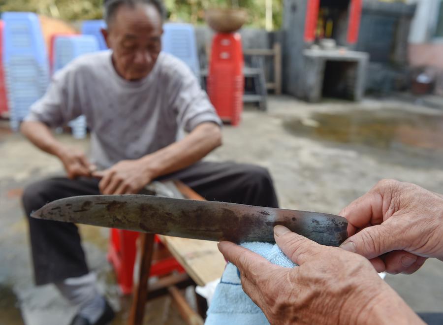 Stunt 'climbing on blades' performs in China's Fujian province