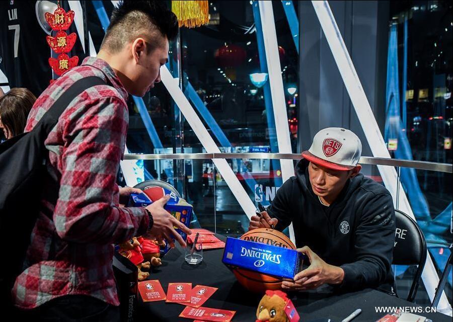 Brooklyn Nets guard Jeremy Lin (R) signs autograph for a fan at a Chinese New Year celebration at the NBA store on Manhattan 5th Avenue, New York City, the United States, on Jan. 24, 2017. Brooklyn Nets guard Jeremy Lin said on Monday he expected to be back to action in 3-5 weeks from his left hamstring injury. (Xinhua/Li Rui) 