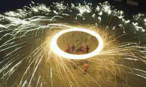 Performers create firework by throwing molten iron