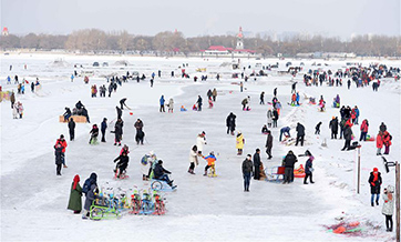Tourists play on frozen Songhua River in Harbin