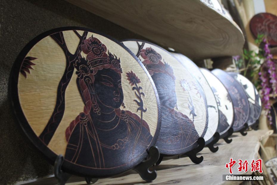 Craftswoman depicts Dunhuang culture through wood carvings