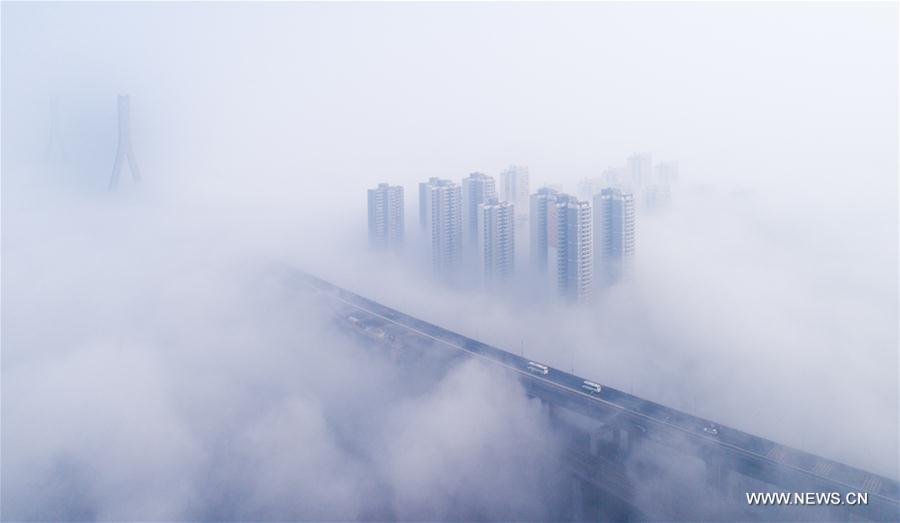 Tianxingzhou Bridge and surrounding buildings are enveloped by heavy fog in Wuhan, capital of central China's Hubei Province, March 7, 2017. 
