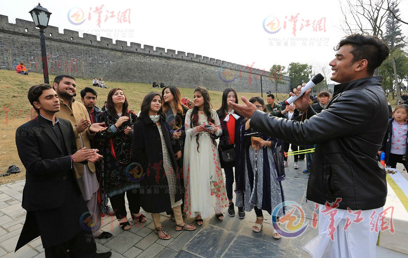 Foreign students sing under ancient city wall