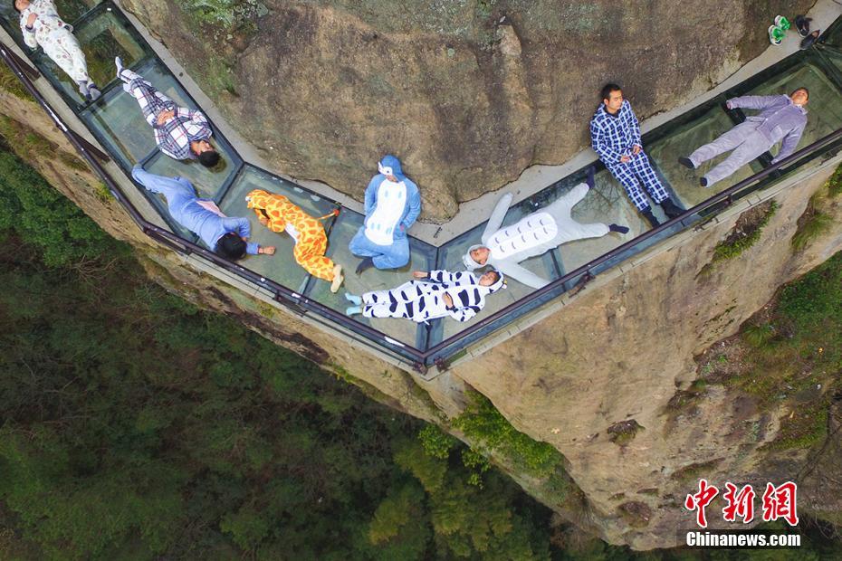 Tourists 'nap' on transparent cliff walkway to highlight sleep health