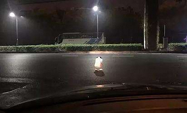 Hangzhou driver uses headlights to protect woman crying in road