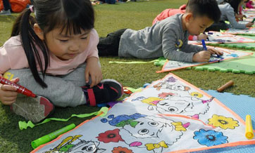 Children fly kites at kindergarten in N China