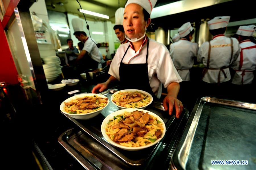 Tourists enjoy firecracker-shaped noodles in Zhangye, NW China's Gansu