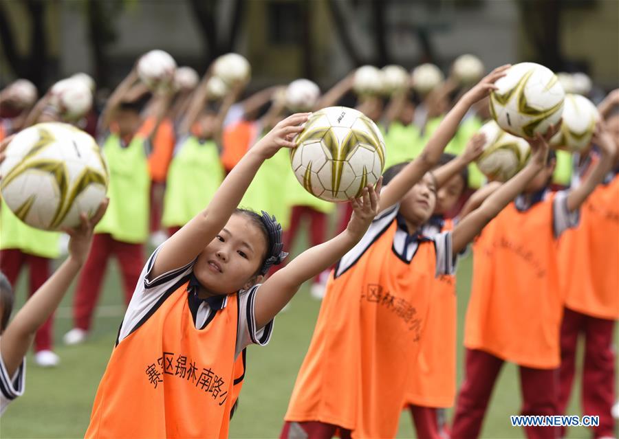Students do football exercises in Hohhot, N China's Inner Mongolia