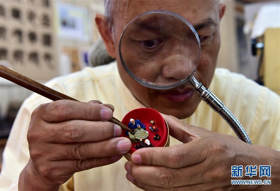 Man engraves miniscule Chinese chess board on tiny copper sheet