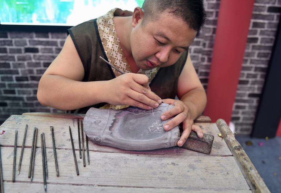 An artist carves a Duan ink slab at the 13th China (Shenzhen) International Cultural Industries Fair in Shenzhen, South China's Guangdong province, May 11, 2017. The 5-day fair started on May 11, attracting 2,302 exhibitors. (Photo/Xinhua)