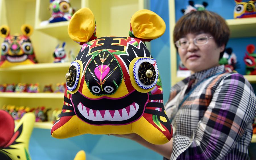 A staff member shows a fabric tiger at Shandong Pavilion at the 13th China (Shenzhen) International Cultural Industries Fair in Shenzhen, South China's Guangdong province, May 11, 2017. The 5-day fair started on May 11, attracting 2,302 exhibitors. (Photo/Xinhua)