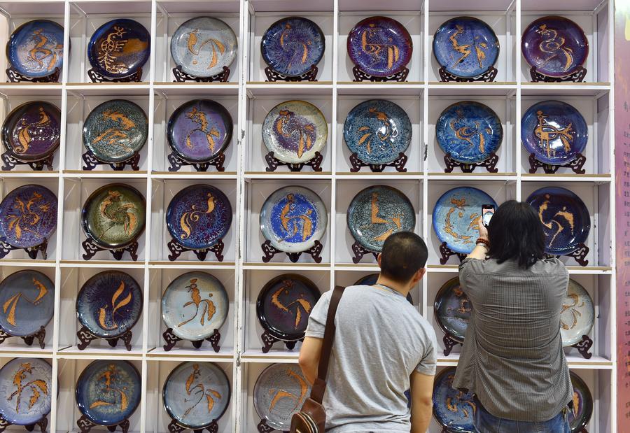 Visitors watch the Jun porcelain plates displayed at the 13th China (Shenzhen) International Cultural Industries Fair in Shenzhen, South China's Guangdong province, May 11, 2017. The 5-day fair started on May 11, attracting 2,302 exhibitors. (Photo/Xinhua)