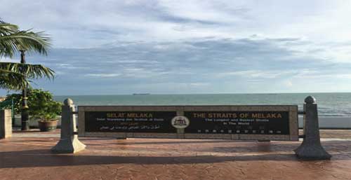 A stone tablet reading "the world's longest and busiest strait" in English, Malay, Chinese and Arabic lays beside the Malacca Strait. (Photo by Yu Yichun from People’s Daily)