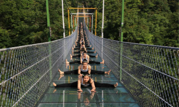 Yoga lovers practice yoga on glass bridge at Shuanglonggou forest park