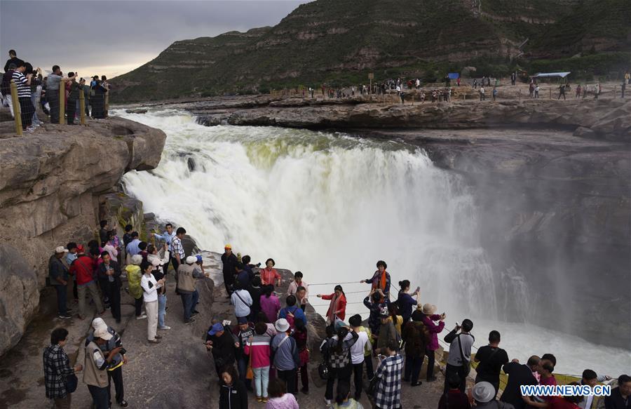 Visitors view Hukou Waterfall in N China