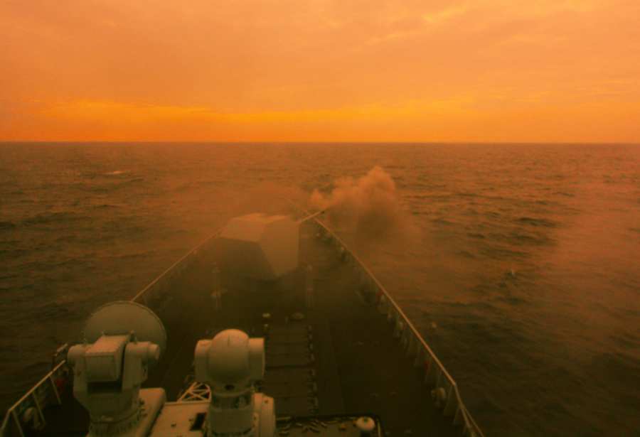 Destroyer fires main gun at night in South China Sea