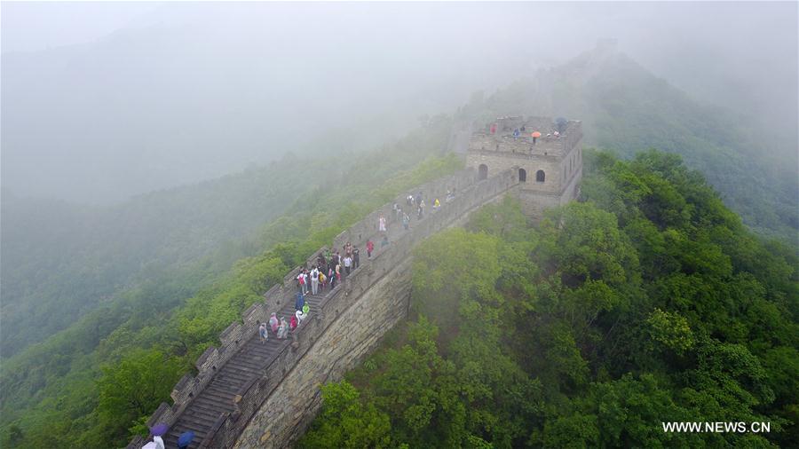 People visit Mutianyu section of Great Wall in mist and rain in Beijing