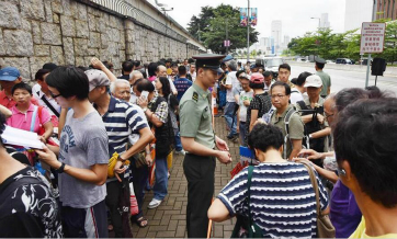 Hong Kong residents line up in rain for free tickets to see the Liaoning