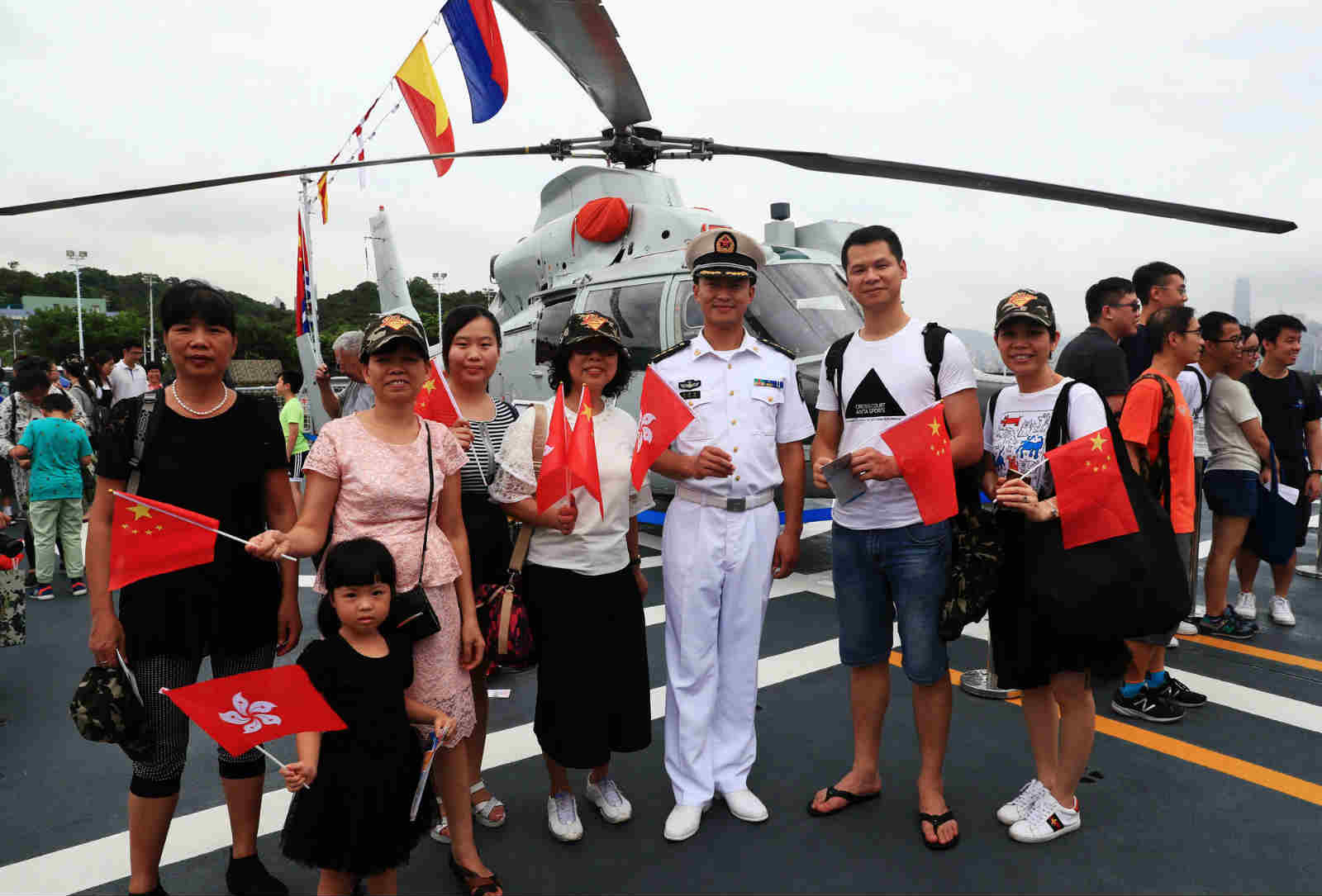 Local residents pose for group photo with a Chinese naval officer on the camp-open day in the Ngong Shuen Chau Barracks. In order to celebrate the 20th anniversary of Hong Kong's return to the motherland, the Ngong Shuen Chau Barracks of the PLA Hong Kong Garrison held the camp-open day activities on the morning of July 8, 2017. (eng.chinamil.com.cn/Photo by Zhou Hanqing)
