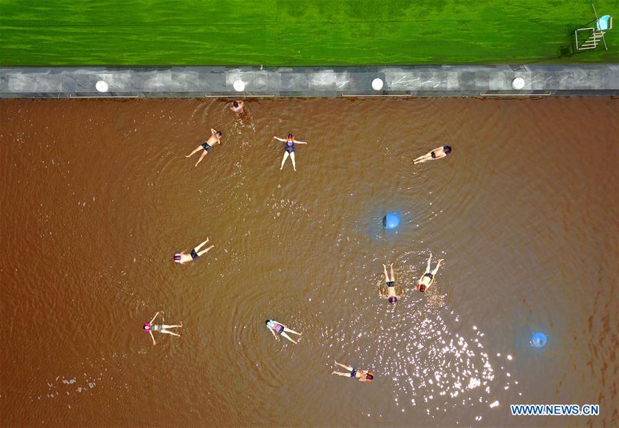 People bath in water with high amount of salt at resort in NE China