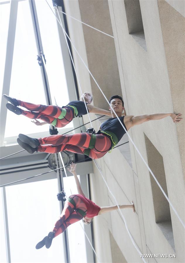 Dancers perform in air on exterior wall of Vancouver Public Library