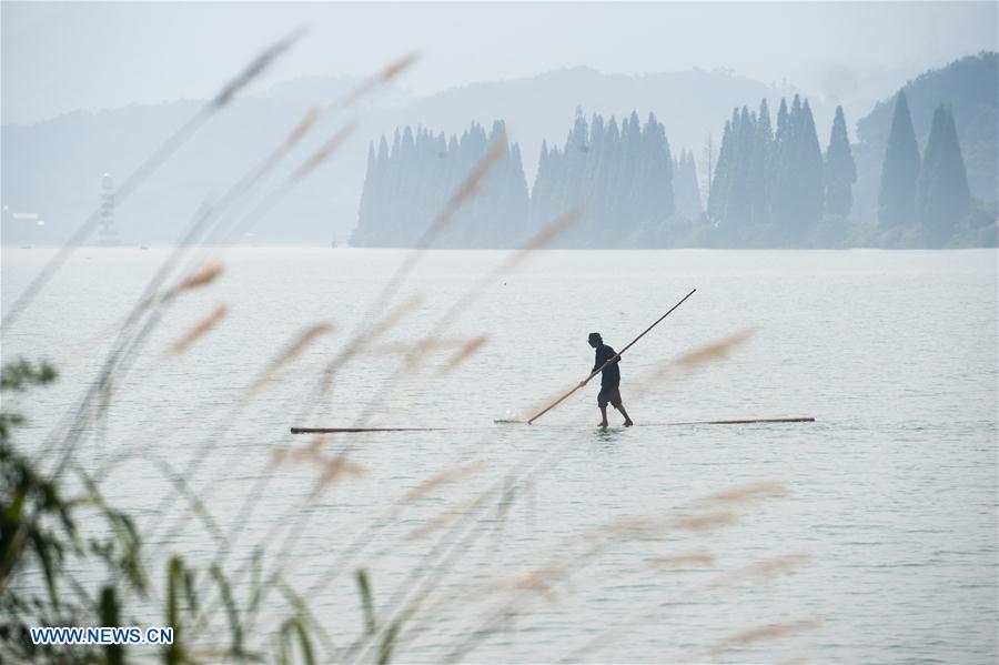 Hangzhou citizen crosses Xin'an River using 2 bamboo poles
