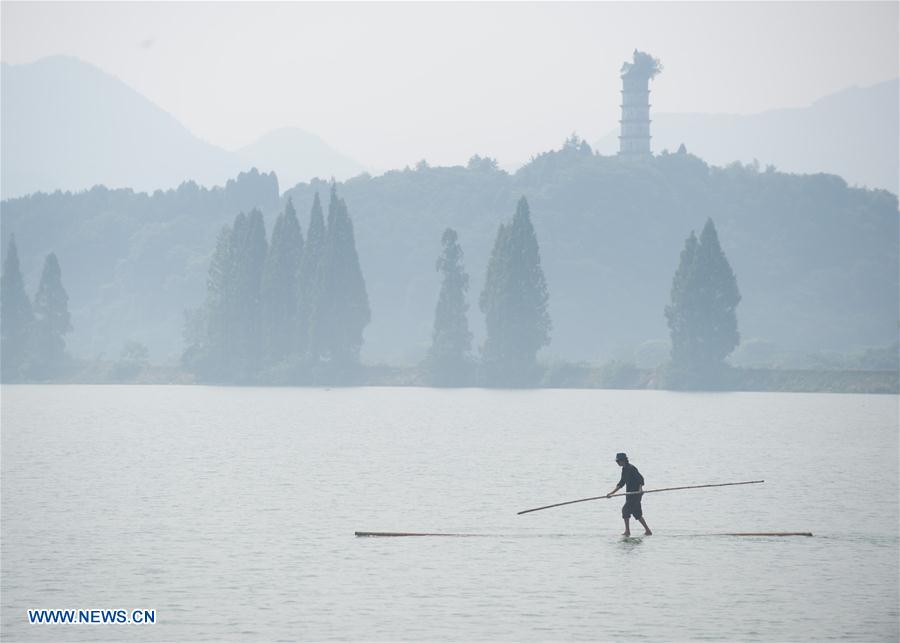 Hangzhou citizen crosses Xin'an River using 2 bamboo poles