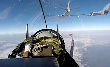 Tanker aircraft pass fuel to fighter jets
