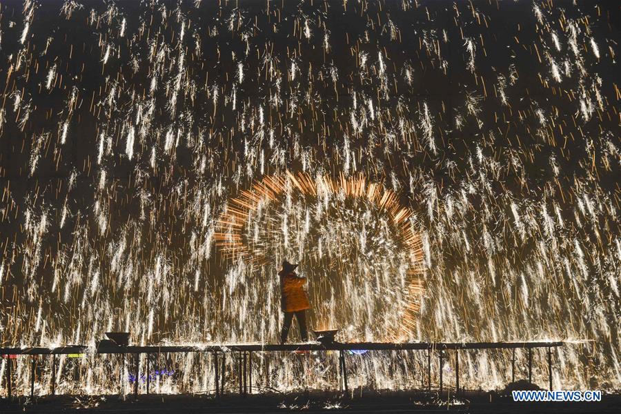 Performers throw molten iron to create fireworks ahead of Lantern Festival in Hebei
