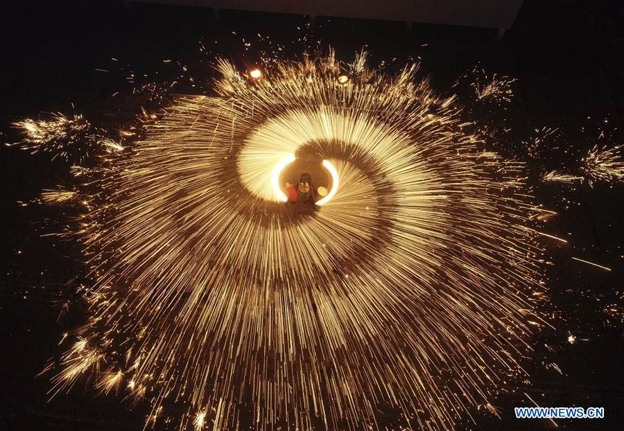 Performers throw molten iron to create fireworks ahead of Lantern Festival in Hebei