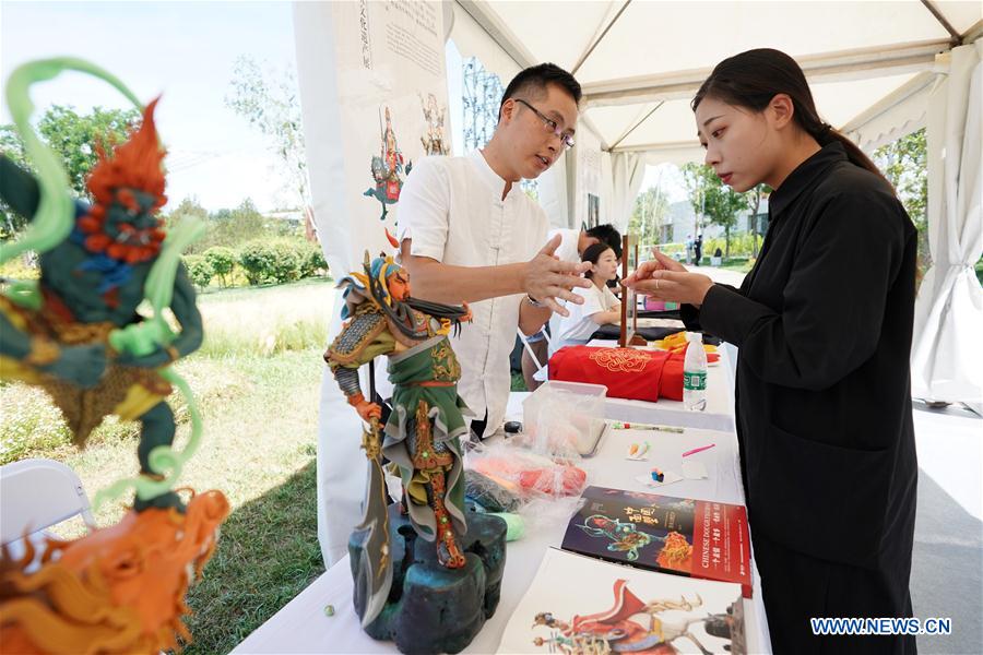 A visitor learns about dough model making during the "Hubei Day" event at the Beijing International Horticultural Exhibition in Beijing, capital of China, July 4, 2019. "Hubei Day," showcasing the culture and ecology of central China''''s Hubei Province, kicked off on Thursday at the ongoing International Horticultural Exhibition in Beijing. (Xinhua/Ju Huanzong)