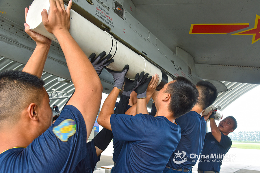 Airmen jointly load missiles before flight