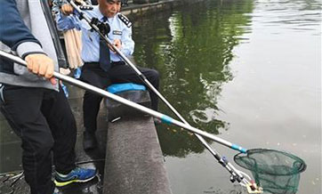 Policeman fishes up six phones for tourists during the national holiday