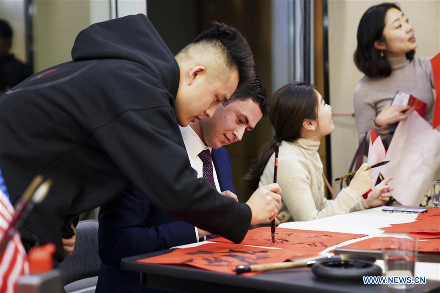 Students write Chinese calligraphy during a New Year gala for Chinese and international youth in New York, the United States, Jan. 19, 2020. The great hall of the Chinese Consulate General in New York was filled with joyful laughter, beautiful melodies and the smell of dumplings on Sunday night. Some 200 Chinese, U.S. and other international college students gathered here for a Lunar New Year Gala to welcome the Year of the Rat. (Xinhua/Wang Ying)