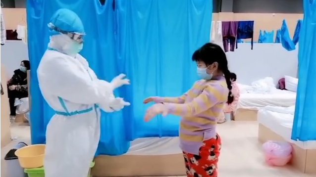 A 9-year-old girl dancing with nurse using sign language