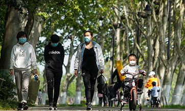 People enjoy spring scenery along Donghu greenway in Wuhan