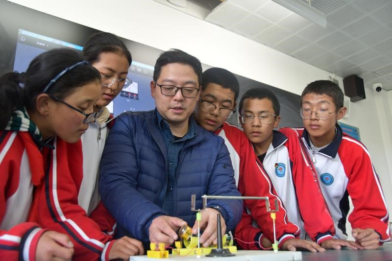 Yao Xueqing (in blue jacket), a teacher from Shanghai working at the Shanghai Experimental School in Shigatse, Tibetan Autonomous Region, teaches students on a class in June. Photo: Courtesy of Yao Xueqing