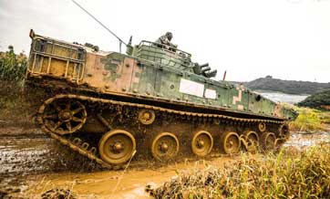 Infantry fighting vehicles drive through mire