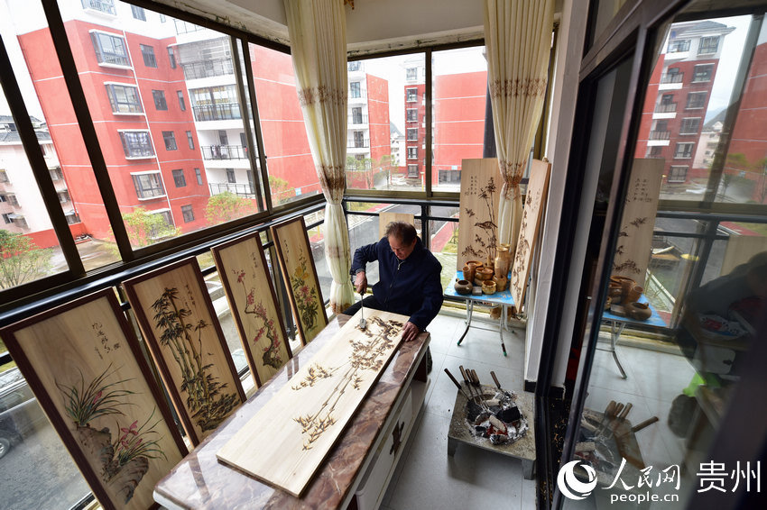 75-year-old carpenter finds new ways to promote pyrography in resettlement area in SW China’s Guizhou