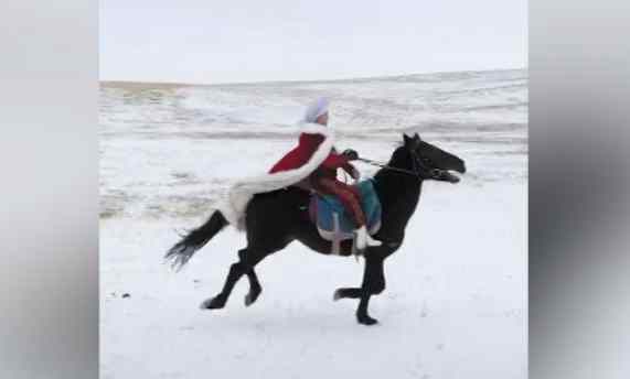 Official in Xinjiang rides a horse in the snow to promote local tourism