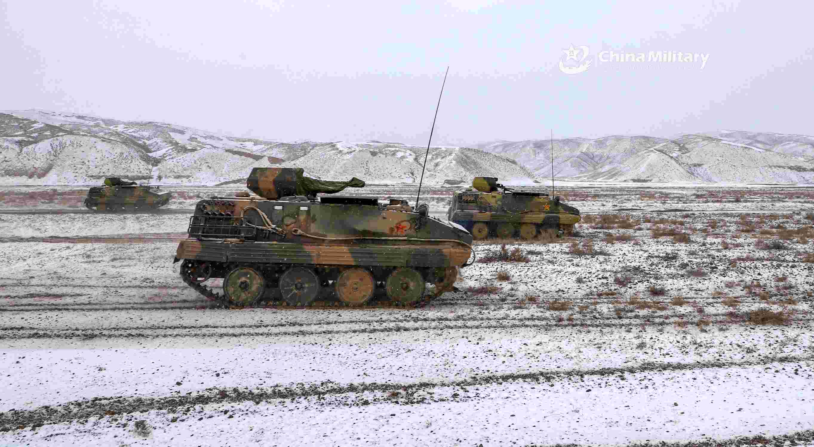 Armored vehicles rumble on snow-covered road