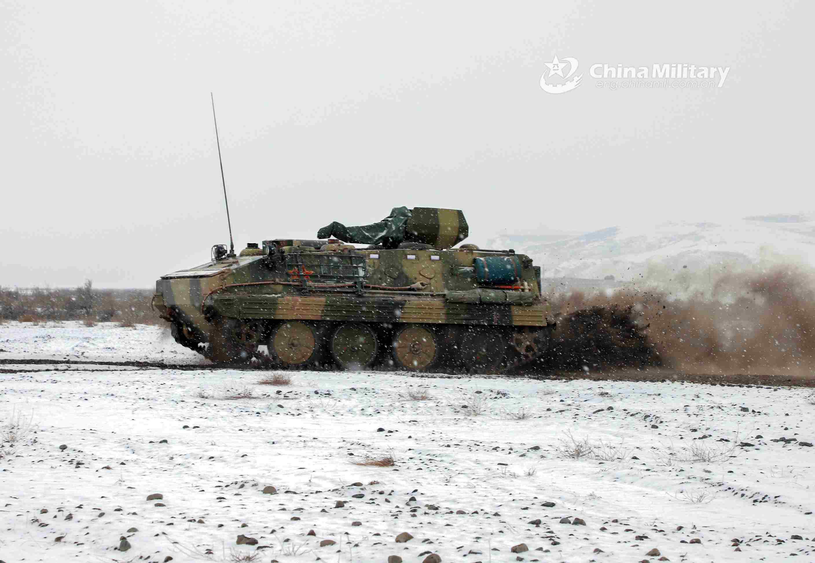 Armored vehicles rumble on snow-covered road