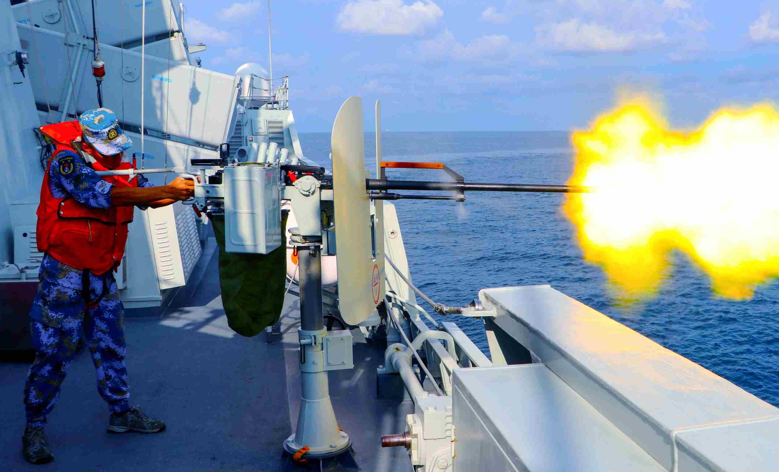 Sailor fires heavy machine gun aboard frigate