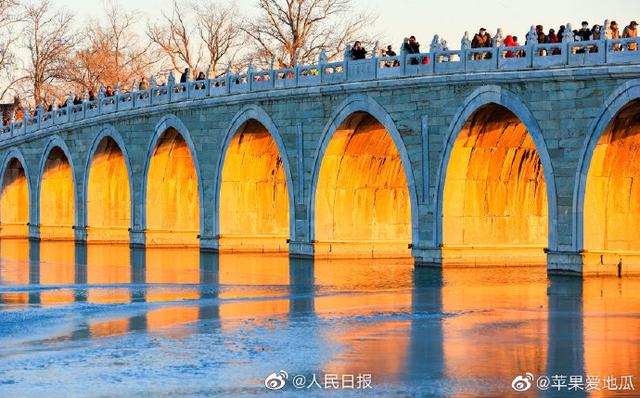 Stunning view of ancient bridge lit by golden winter sunshine at the Summer Palace in Beijing