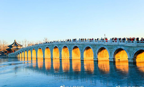 Stunning view of ancient bridge lit by golden winter sunshine