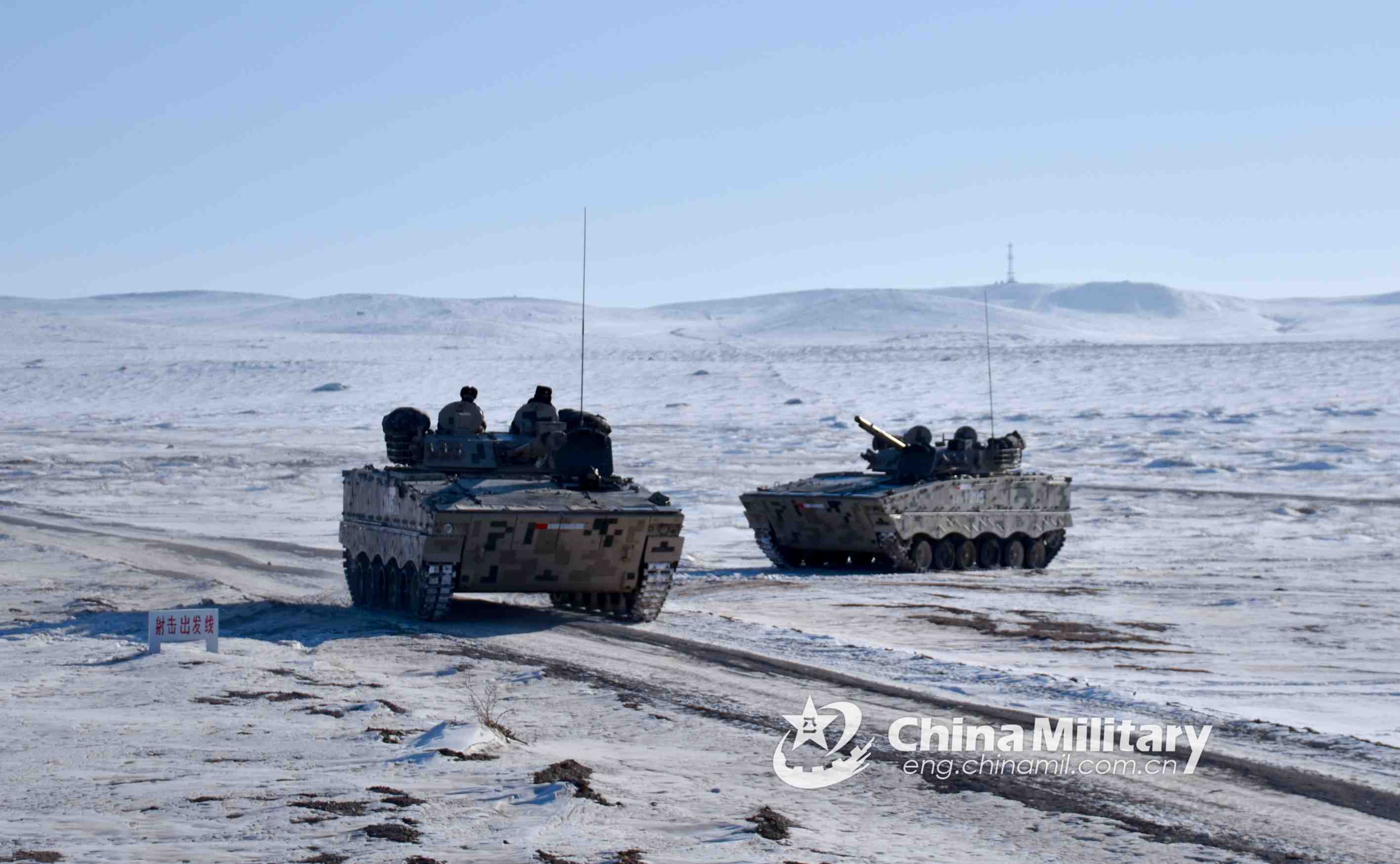 Soldiers drive armored vehicles on snow ground