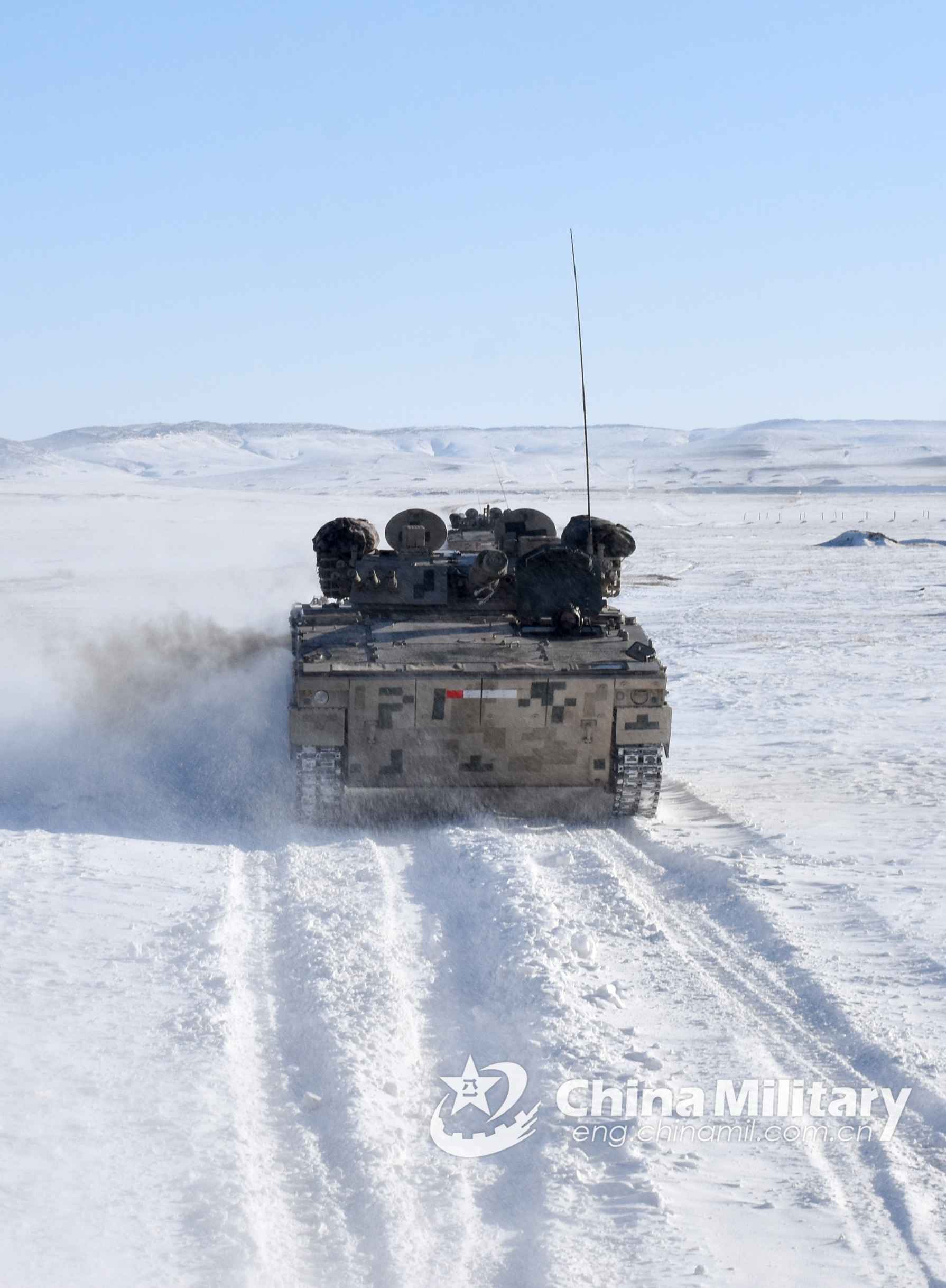 Soldiers drive armored vehicles on snow ground