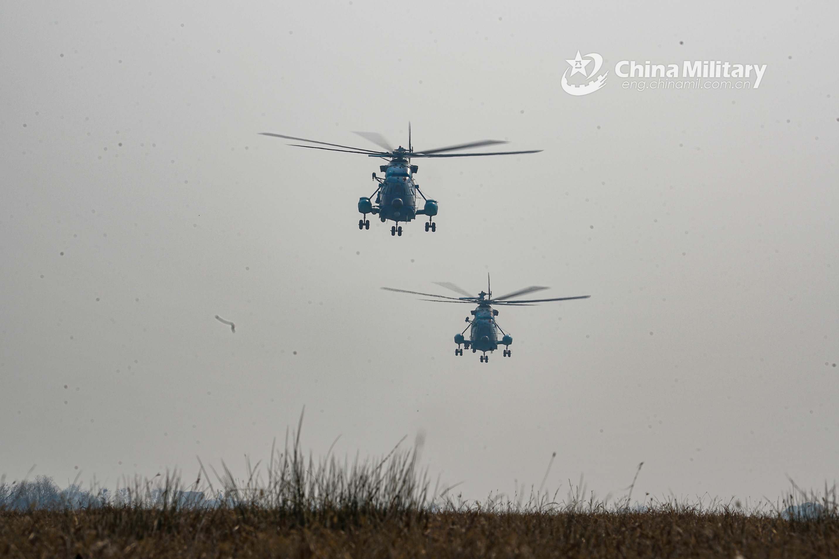 Two WZ-10 attack helicopters attached to a regiment of the PLA airborne troops conduct hover check before leaving for their maiden flights this year on January 4, 2021. (eng.chinamil.com.cn/Photo by Deng Xiaoning)