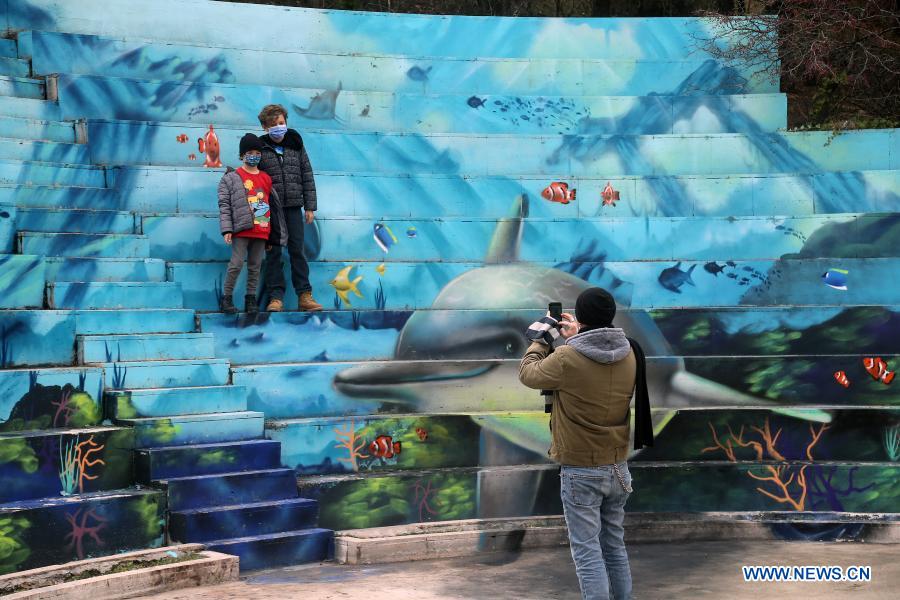 People take photos with graffiti at a park in Ankara, Turkey on Feb. 2, 2021. Turkey's capital Ankara has been dubbed grayish, comparing with the colorful Istanbul, but graffiti artists are changing this stereotype perception, bringing colors to parks in times of the COVID-19 pandemic. (Photo by Mustafa Kaya/Xinhua)
