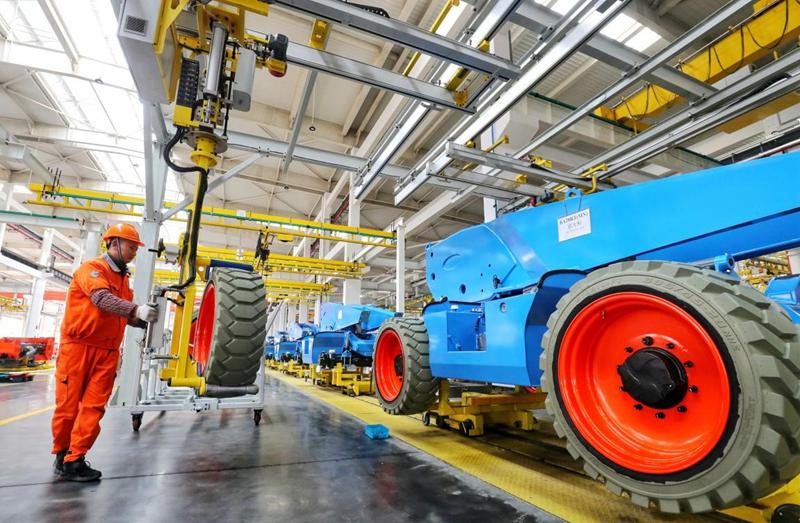 Workers manufacture engine boom lifts to be exported at a factory of Zhejiang Dingli Machinery Co., Ltd., Huzhou, east China’s Zhejiang Province, Jan. 21, 2021. (People’s Daily Online/Xie Shangguo)